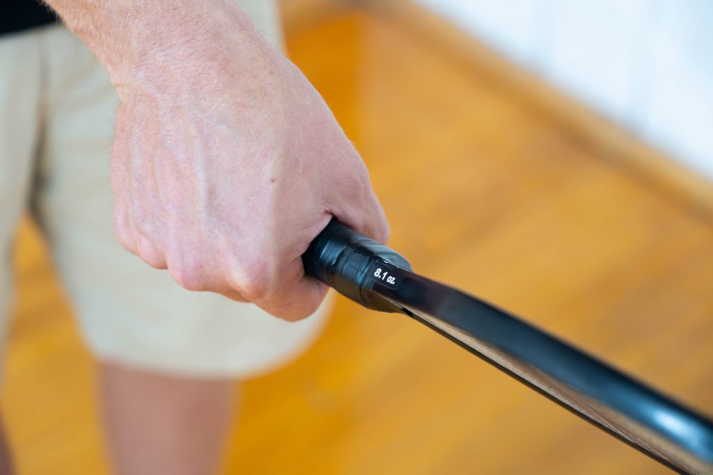 A picture of a hand holding a pickleball paddle.