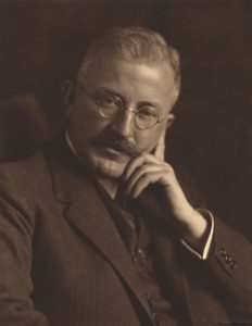 Photograph of Hermann Staudinger, an older man with glasses and a mustache wearing a suit.